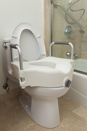 Elevated toilet seat placed on toilet.