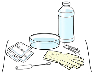 Supplies for cleaning tracheostomy tube placed on clean towel..