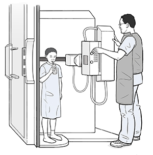 Child standing in fluoroscopy scanner sipping liquid through straw while provider adjusts scanner.