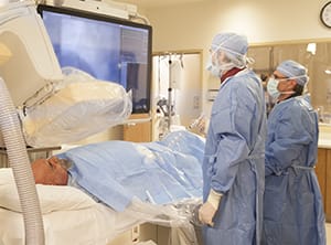 Two technicians performing angiography on patient.