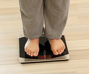 Closeup of person's feet on bathroom scale.