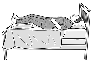 Man lying on back in bed with pillow under head and pillow under lower legs.