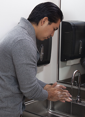 Man washing hands in sink.