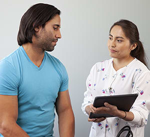Doctor talking to man in exam room.
