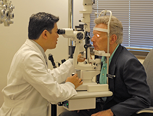 Heathcare provider examining man's eyes.