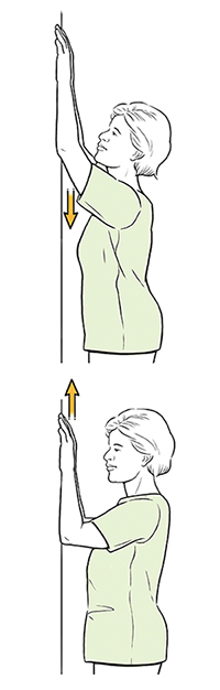 Mujer haciendo un ejercicio de subir los brazos contra la pared.