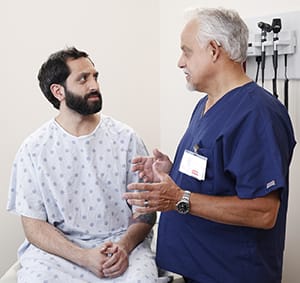 Patient talking to doctor in exam room.